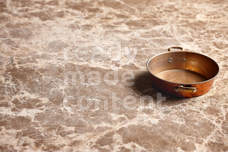 Small Copper Pan on Beige Marble Flooring, 45 degrees