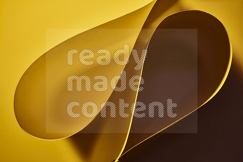 An abstract art of paper folded into smooth curves in yellow gradients