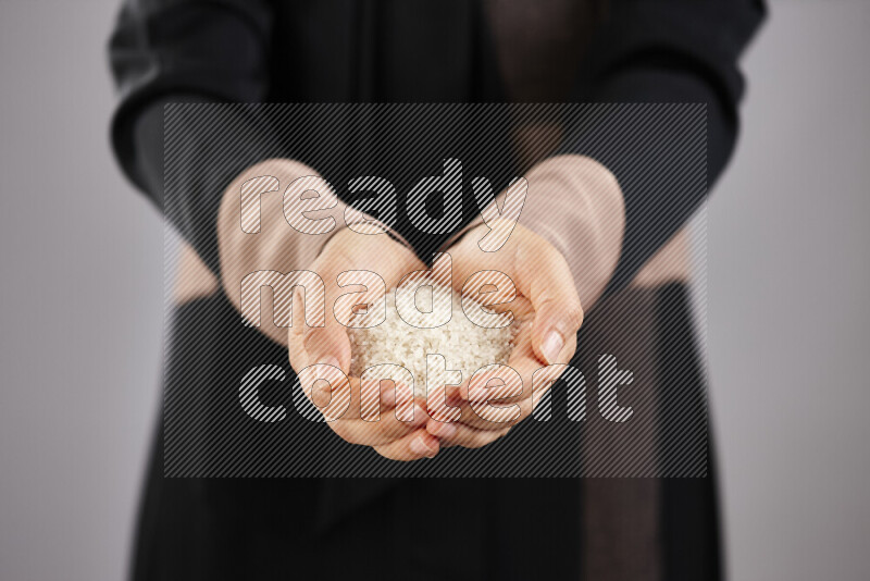 Woman in abaya holding different kinds of legumes in different positions