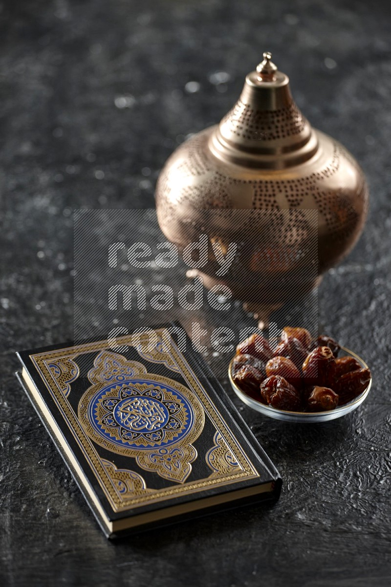 Quran with a prayer beads on textured black background
