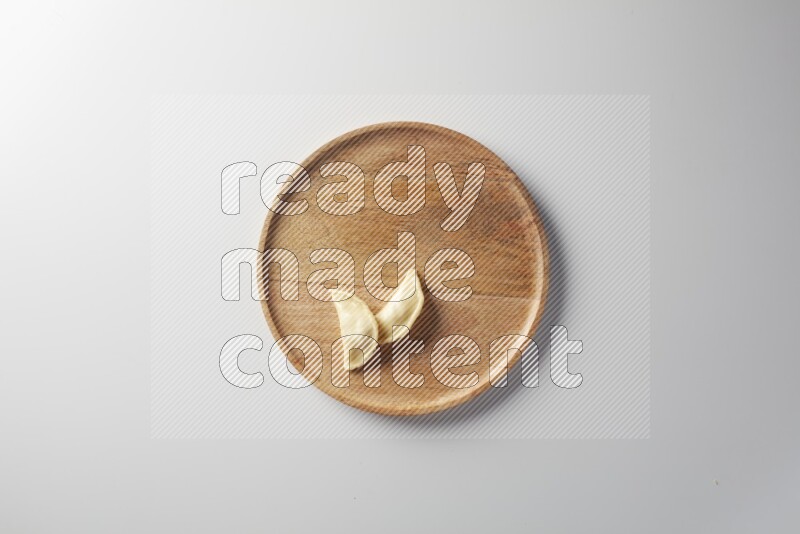 Two Sambosas on a wooden round plate on a white background