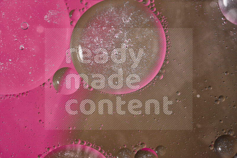 لقطات مقربة لفقاعات من الزيت على سطح الماء باللون الوردي والبني