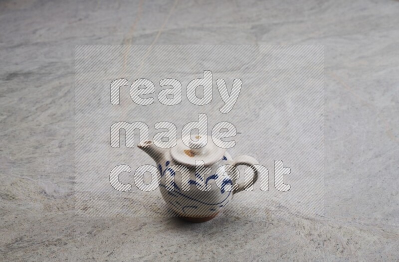 A pottery teapot on grey marble background