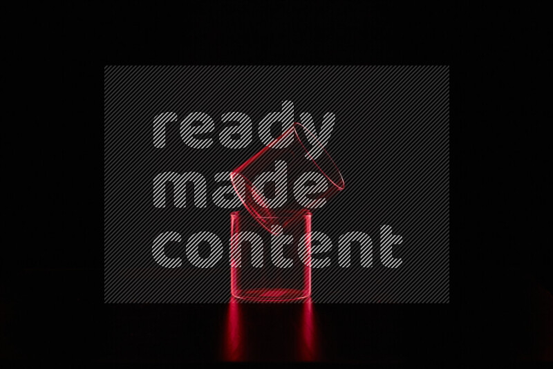 Glassware with rim light in red against black background