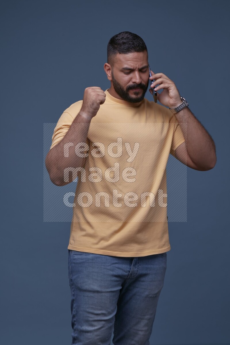 A man Calling on Blue Background wearing Orange T-shirt