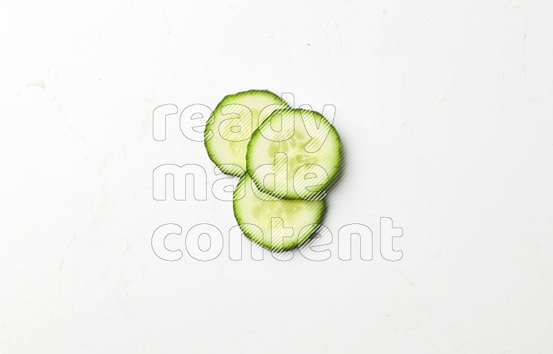 three cucumber slices on white background