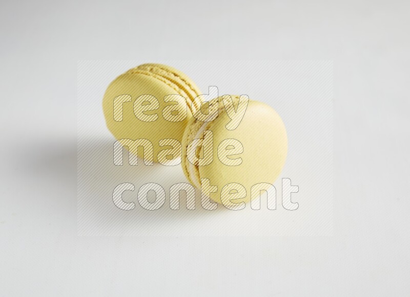 45º Shot of two Yellow Lime macarons on white background