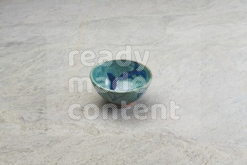 A multicolored pottery bowl on grey marble background