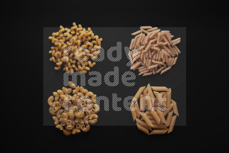 Different pasta types in bunches on black background