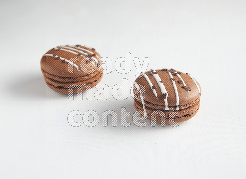 45º Shot of two Brown white Chocolate Caramel macarons on white background