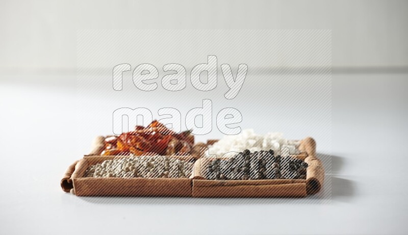 4 squares of cinnamon sticks full of red chilis, salt, white pepper, and black pepper on white flooring