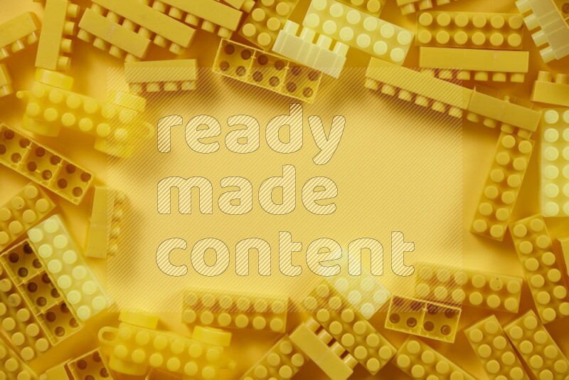 مكعبات بناء بلاستيكية صفراء على خلفية صفراء (ألعاب للأطفال)