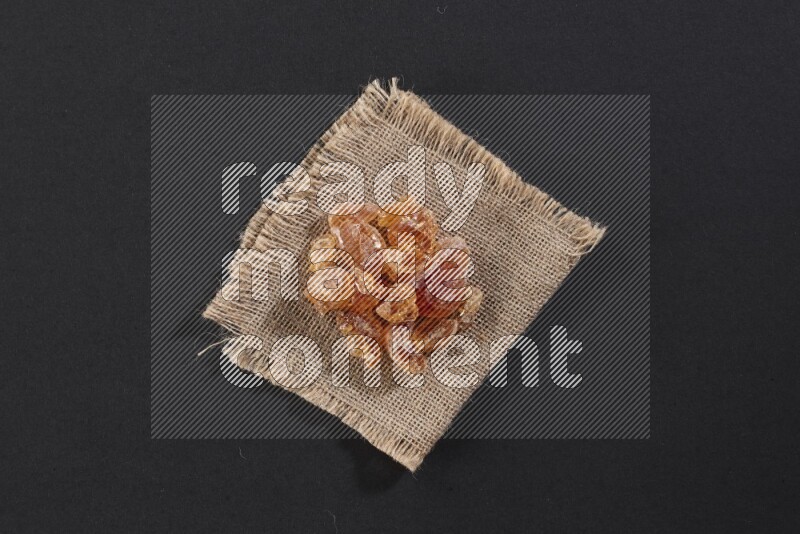 Gum arabic on a burlap piece on black flooring