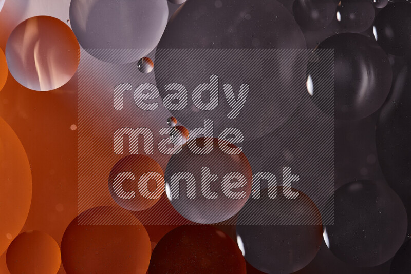 لقطات مقربة لفقاعات من الزيت على سطح الماء باللون الأسود والبرتقالي