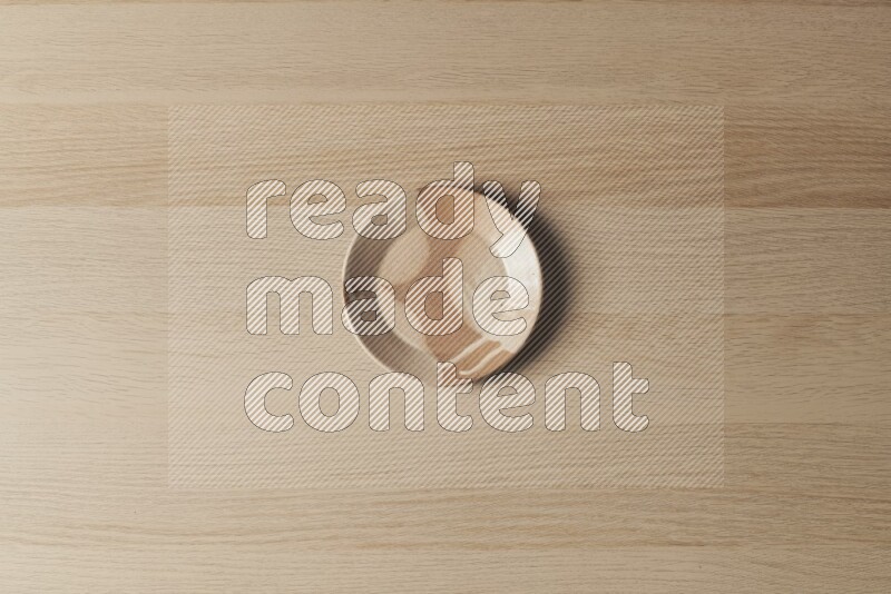 صحن فخاري متعدد الألوان على خلفية خشبية فاتحة