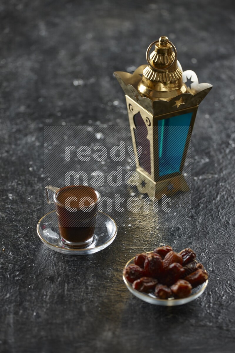 A golden lantern with different drinks, dates, nuts, prayer beads and quran on textured black background