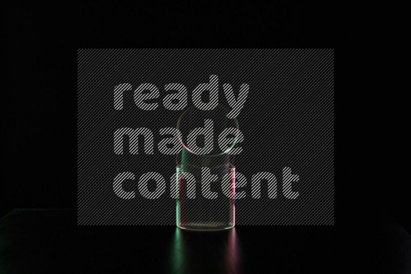 Glassware with rim light in red and green against black background