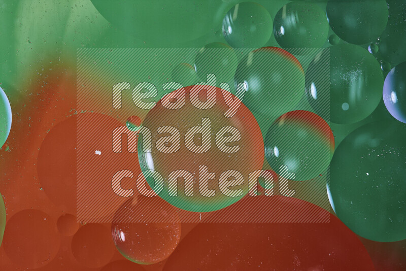 لقطات مقربة لفقاعات من الزيت على سطح الماء باللون الأخضر والأحمر