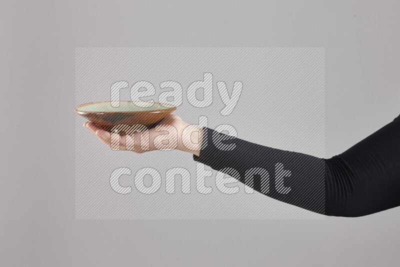 امرأة ترتدي عباءة سوداء تحمل أدوات فخارية مختلفة في أوضاع متعددة