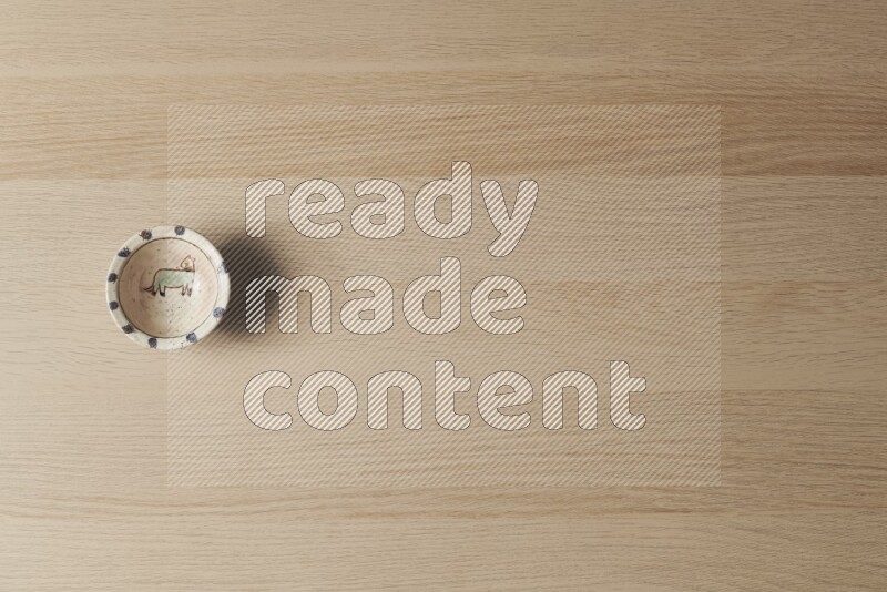 وعاء فخاري مزخرف على خلفية خشبية فاتحة