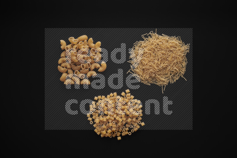 Different pasta types in bunches on black background