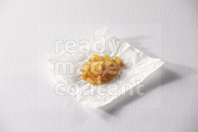 Raisins on a crumpled piece of paper on a white background in different angles