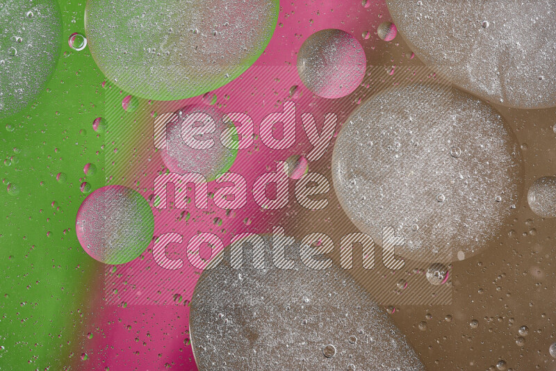 لقطات مقربة لفقاعات من الزيت على سطح الماء باللون البني والأخضر والوردي