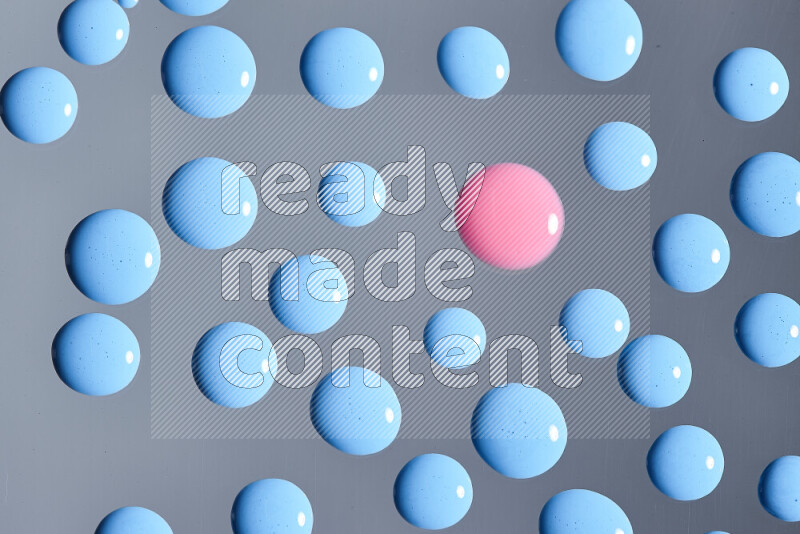 Close-ups of abstract pink and blue paint droplets on the surface