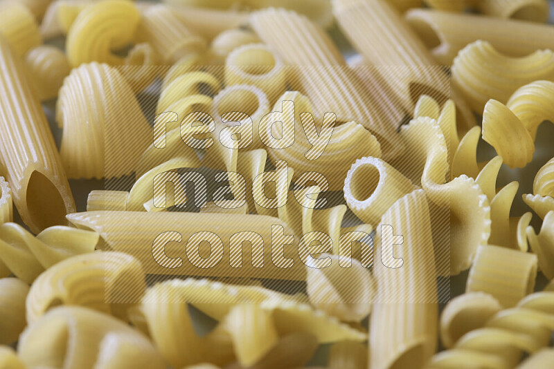 Different pasta types on light blue background