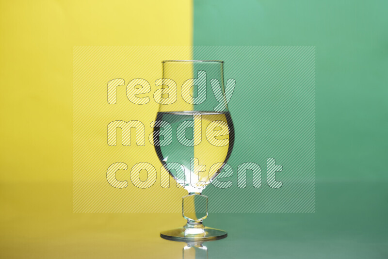 The image features a clear glassware filled with water, set against yellow and green background