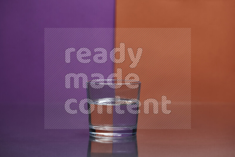 The image features a clear glassware filled with water, set against purple and dark orange background