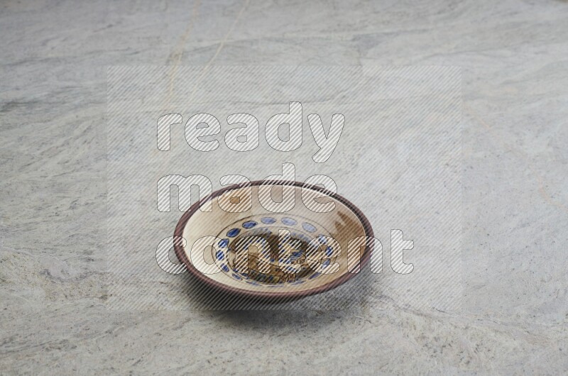 A decorative pottery plate on grey marble background