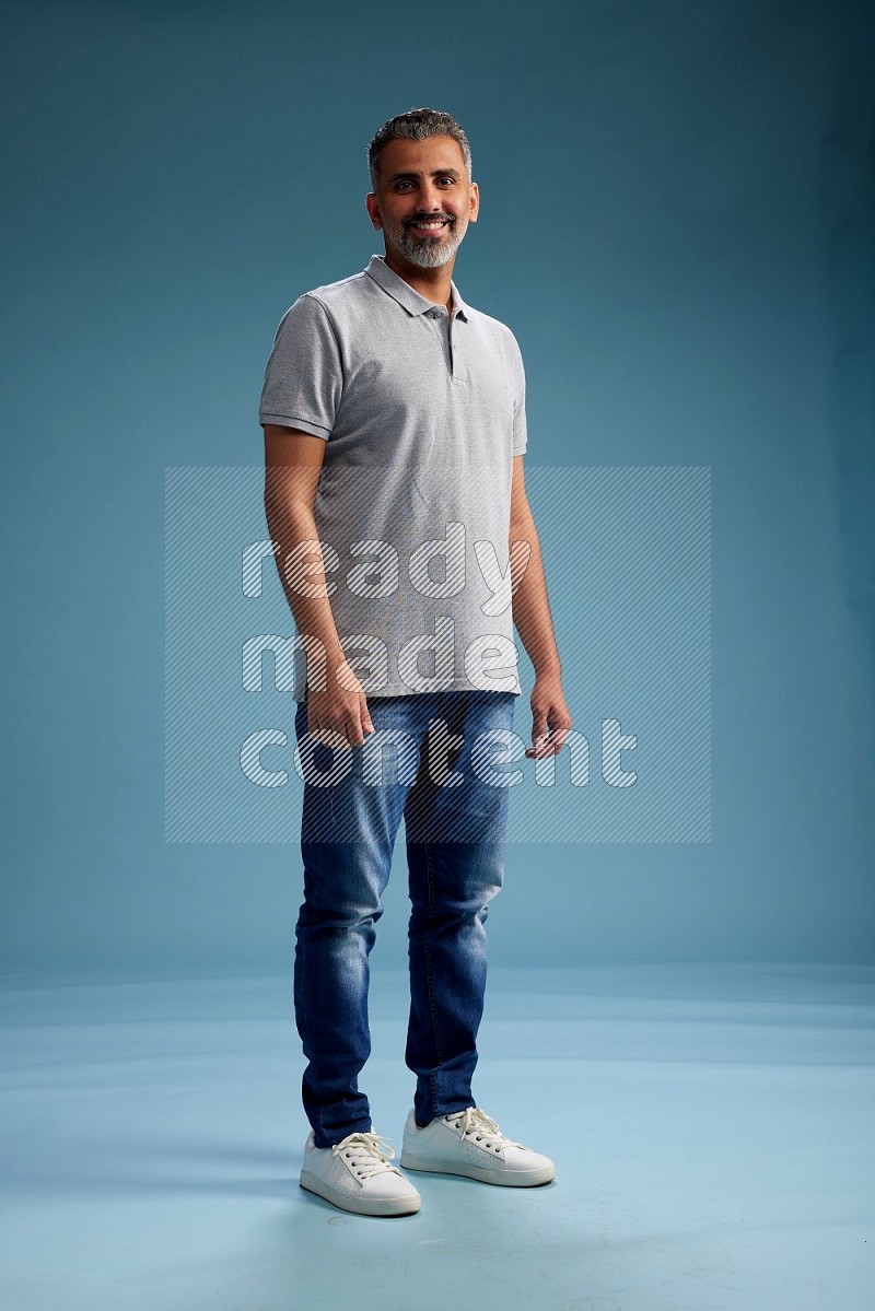 Man Standing Interacting with the camera on blue background