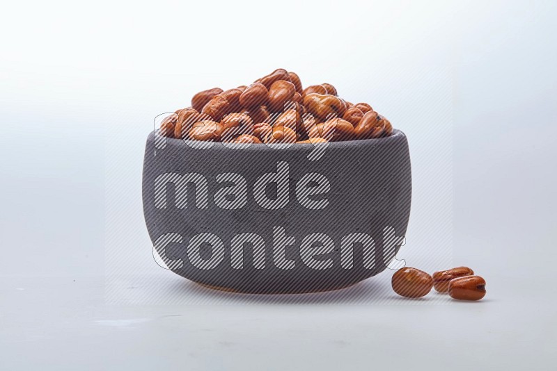 Close up shot of cooked fava beans (foul) in a container on white background