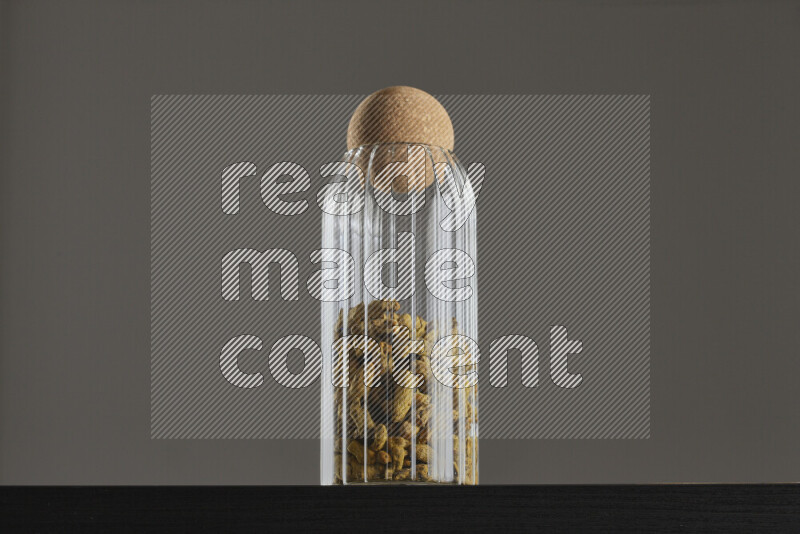 Turmeric in a glass jar on black background