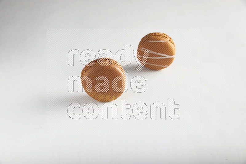 45º Shot of of two assorted Brown Irish Cream, and Brown Coffee macarons  on white background