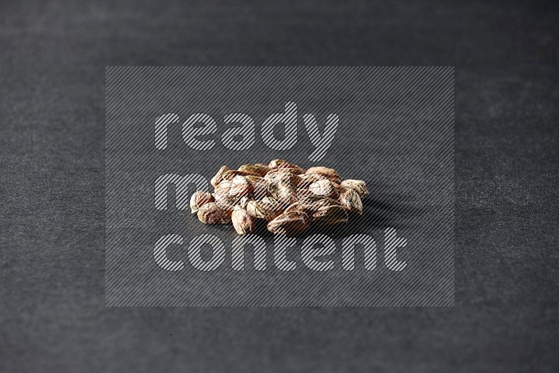 A bunch of peeled pistachios on a black background in different angles