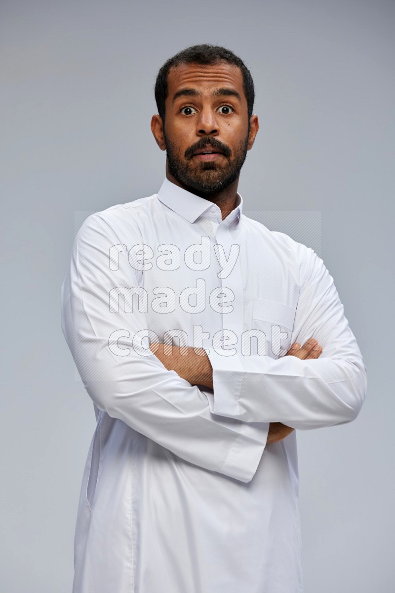Saudi man wearing Thob standing with crossed arms on Gray background