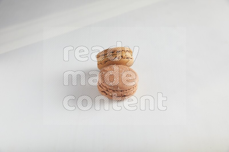45º Shot of of two assorted Brown Irish Cream, and Brown Hazelnuts macarons on white background