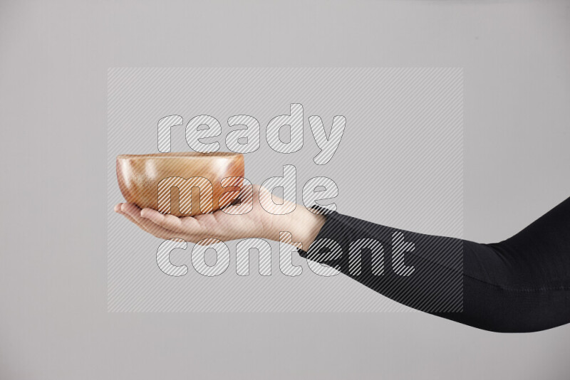 A woman in black abaya holding different wooden essentials in different positions