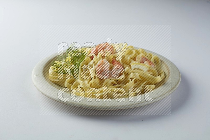 Fettuccini white sauce pasta with shrimp in a white plate on a white background