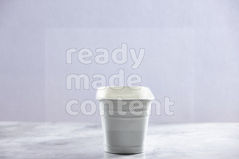 An empty white plant pot on grey marble background