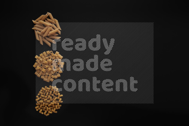 Different pasta types in 3 bunches on black background
