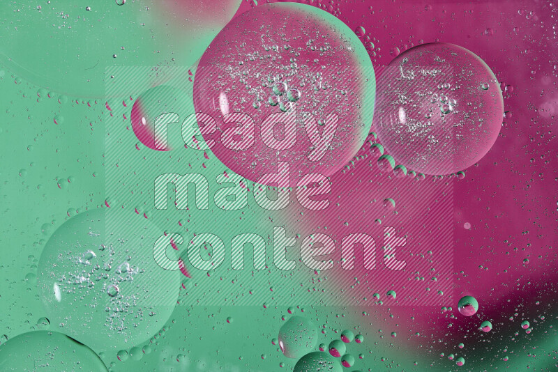 Close-ups of abstract oil bubbles on water surface in shades of green and pink