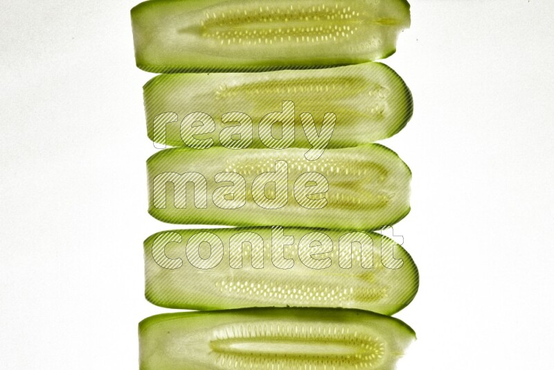 Zucchini slices on illuminated white background