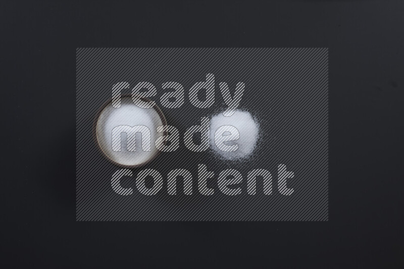 وعاء فخاري ممتلئ بملح الطعام الناعم وملح البحر الخشن على خلفية سوداء