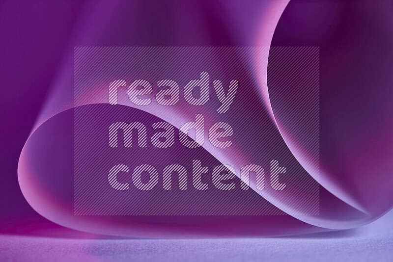 An abstract art piece displaying smooth curves in purple gradients created by colored light