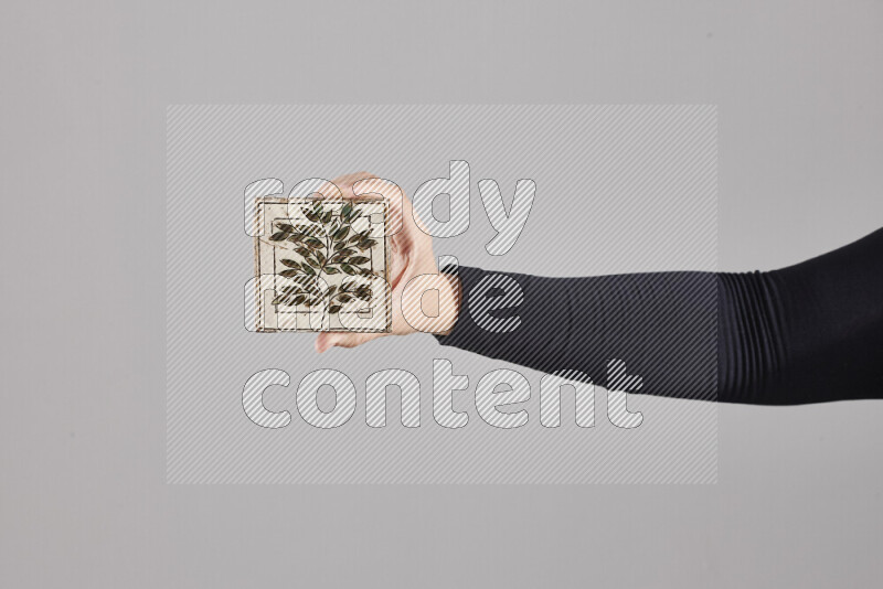 A woman in black abaya holding different pottery essentials in different positions