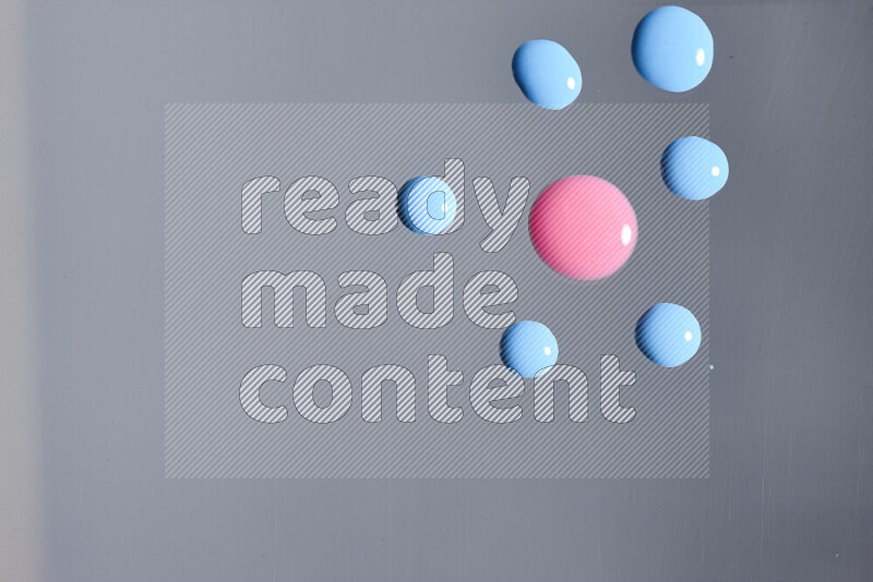 لقطات مقربة لقطرات من اللون الوردي والأزرق على الخلفية