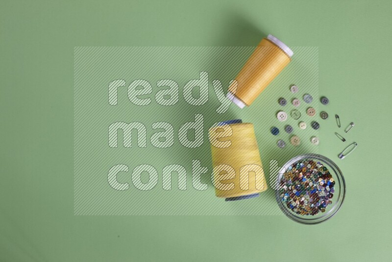 مجموعة من أدوات الخياطة والتفصيل على خلفية خضراء